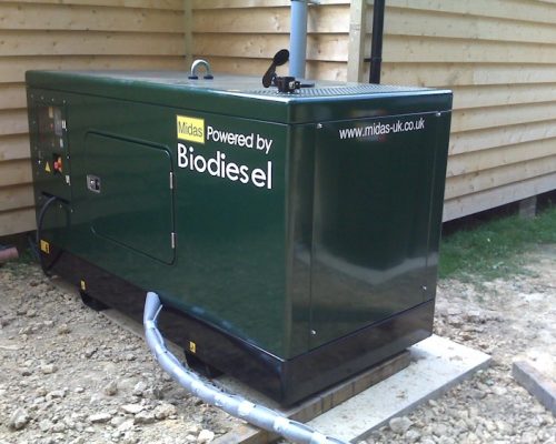 Midas generator powered by biodiesel, located on a gravel surface near wooden structure, showcasing sustainable energy solutions for various sectors.