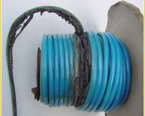 Damaged electrical cable coil with burnt insulation, highlighting safety concerns in generator use and maintenance for Midas Generator Hire.