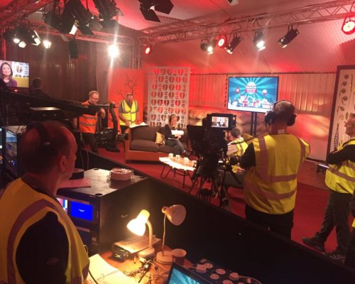 Event production setup with crew in high-visibility vests, cameras, and lighting, powering Costa Coffee's business update launch.
