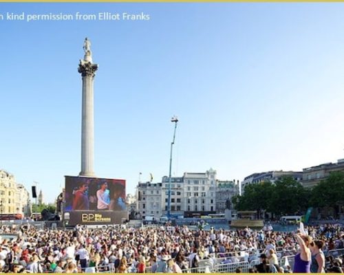 Crowd gathered in Trafalgar Square celebrating BP Big Screens' 25th anniversary with live streaming of La Traviata on large screen.
