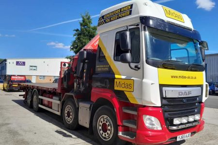 Midas HIAB crane-equipped vehicle for fuel tank and generator delivery, showcasing branding and operational capability in a commercial setting.