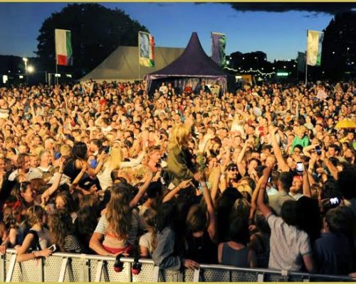 Crowd enjoying a music festival with raised hands and a vibrant atmosphere, reflecting the lively events supported by Midas Generator Hire.